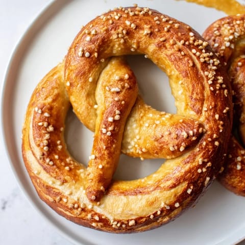 Golden-brown Soft Pretzels, freshly baked and ready to eat, served with tangy mustard for dipping.