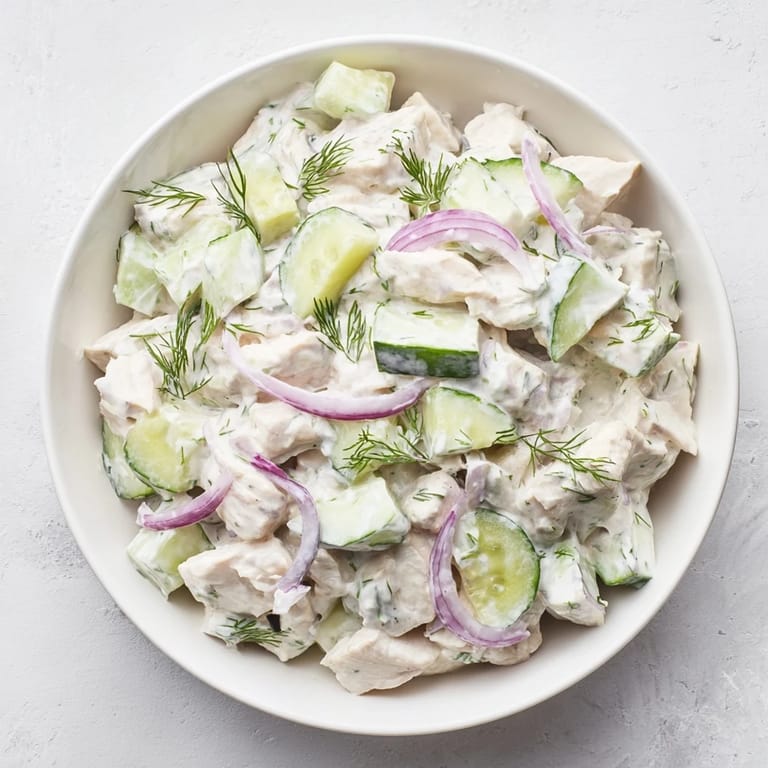 Close-up of a fork lifting a bite of creamy cucumber chicken salad with tender chicken, crisp cucumber, and creamy dill yogurt dressing.