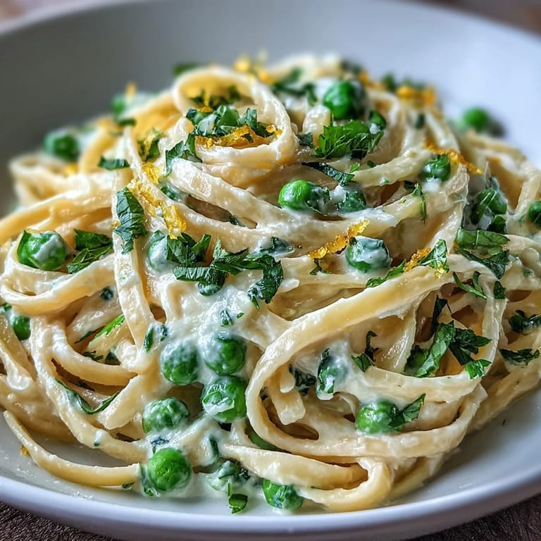 Spring pasta with ricotta and lemon, tender linguine tossed with sweet peas, garlic, and a silky cheese sauce.