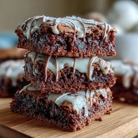 Baseball-themed brownie bites with white icing laces shaped like baseballs, perfect for game day parties or sports celebrations.